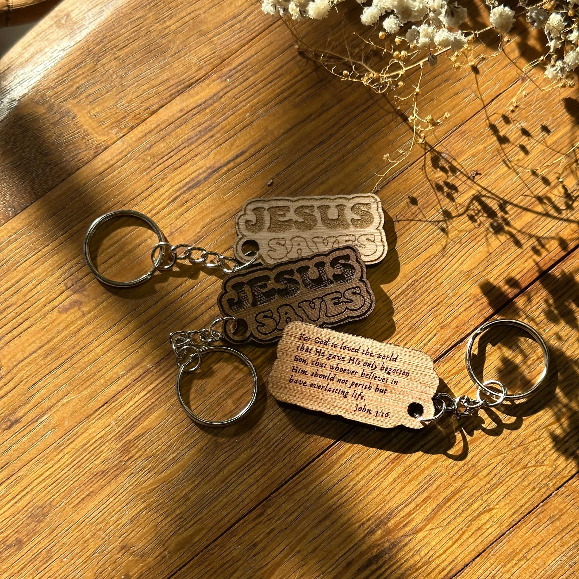Keychain with 'Jesus Saves' and wooden tag on a wooden surface