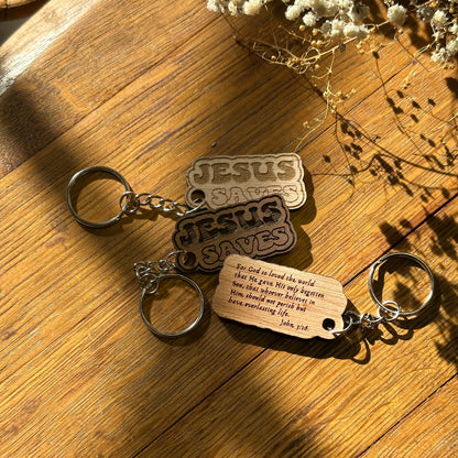 Keychain with 'Jesus Saves' and wooden tag on a wooden surface
