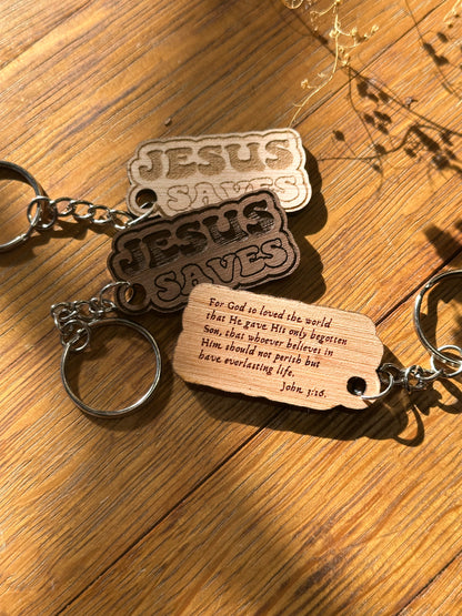 Keychain with 'Jesus Saves' tags and a wooden tag on a wooden surface