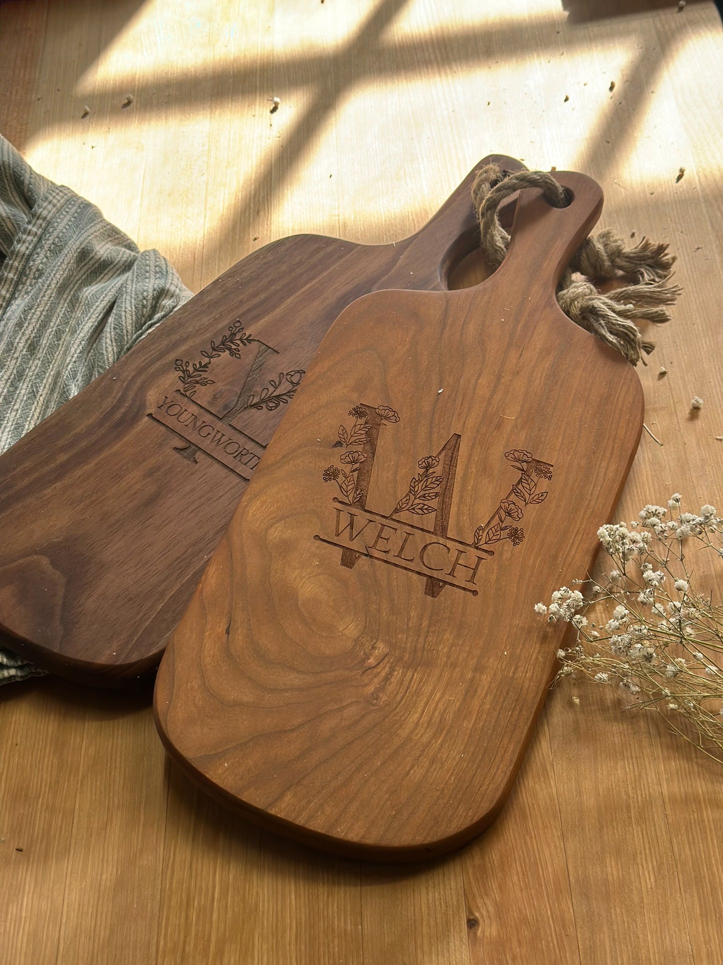 Two wooden cutting boards with engraved branding on a wooden surface.