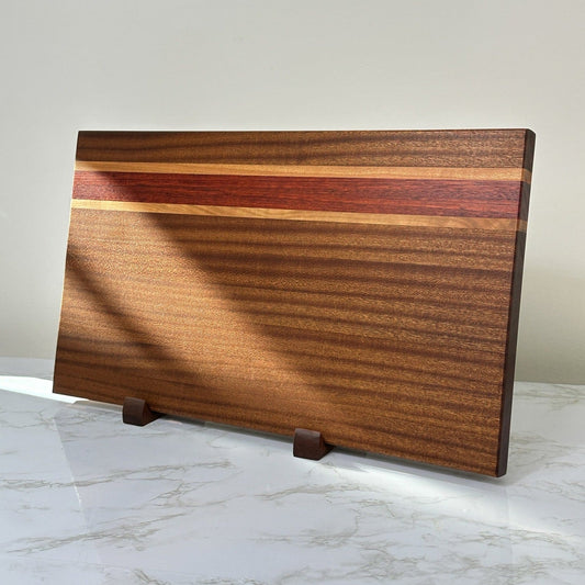 https://cornerstonewoodcraft.com/cdn/shop/products/exotic-sapele-inlay-handmade-wooden-cutting-board-rts-279555.jpg?v=1692233417&width=533